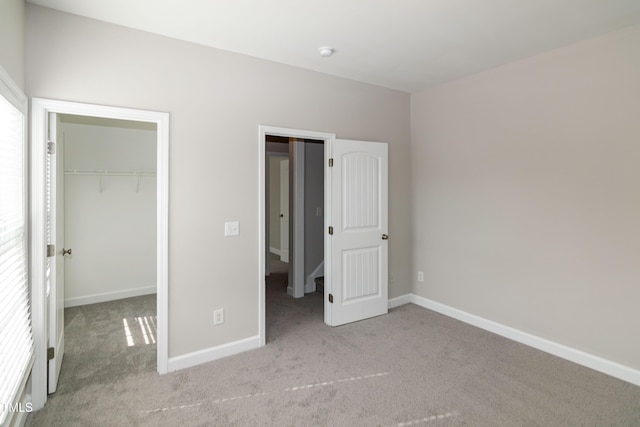 104 Mainline Station Dr, Durham, NC 27560 - unfurnished bedroom featuring carpet flooring, a closet, a walk in closet, and multiple windows