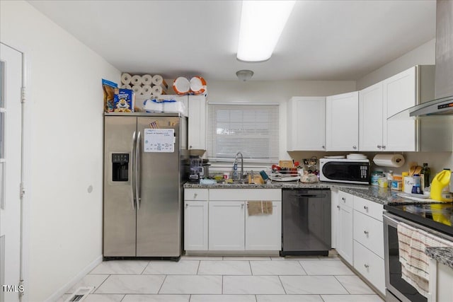 kitchen with white cabinetry, stainless steel appliances, sink, and dark stone counters