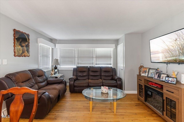 living room with a textured ceiling and light hardwood / wood-style floors