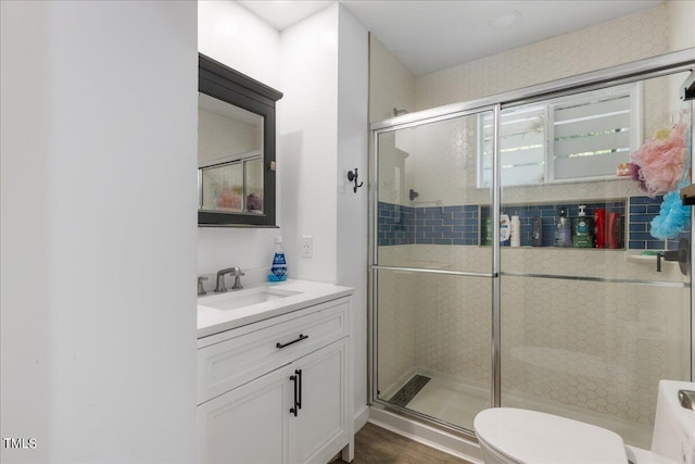 bathroom with vanity, an enclosed shower, and toilet