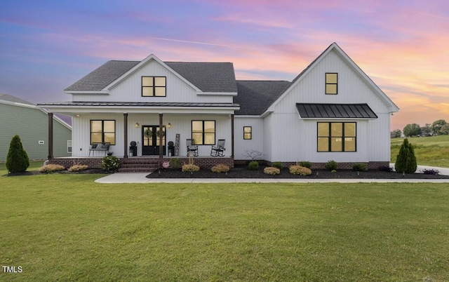 modern farmhouse with a lawn and covered porch