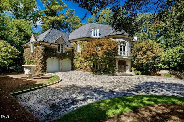 view of front of house featuring a garage and a balcony