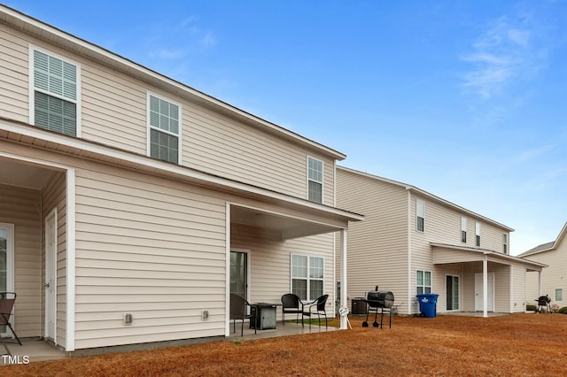 rear view of property featuring a yard and a patio area