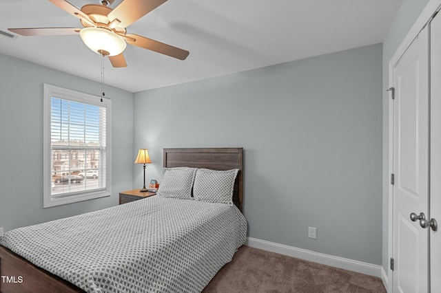 carpeted bedroom featuring ceiling fan and a closet