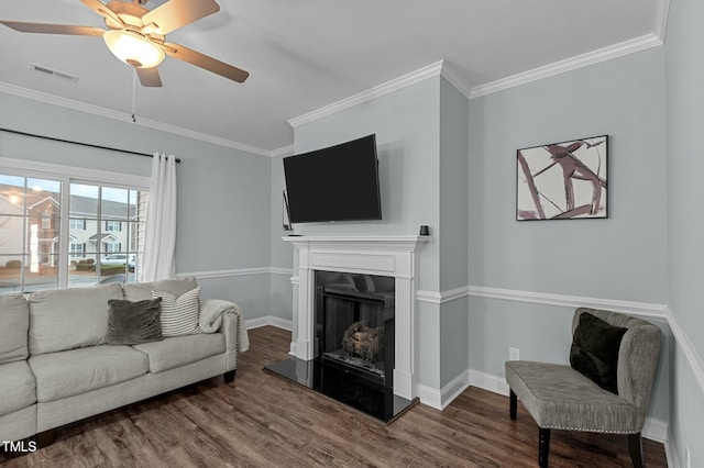 living room featuring hardwood / wood-style flooring, crown molding, and a premium fireplace