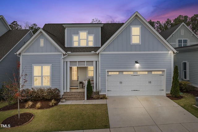 view of front of house with covered porch, a garage, and a lawn