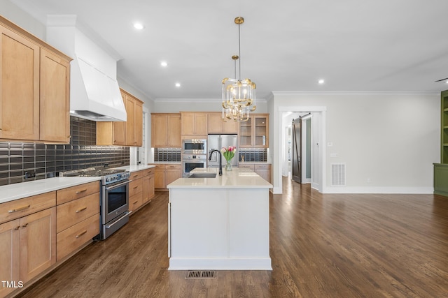 kitchen with a center island with sink, stainless steel appliances, ornamental molding, dark hardwood / wood-style floors, and decorative backsplash