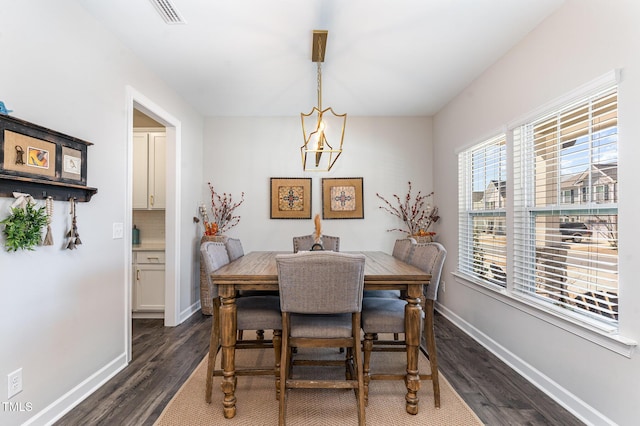 dining room with dark wood-style floors, visible vents, and baseboards