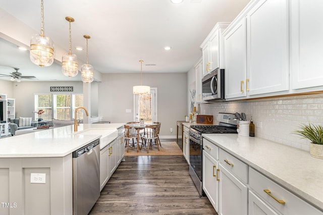 kitchen with appliances with stainless steel finishes, light countertops, and pendant lighting