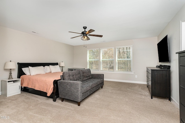 bedroom with a ceiling fan, light colored carpet, and baseboards