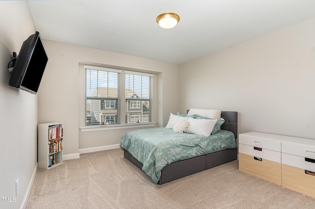 bedroom featuring baseboards and light colored carpet