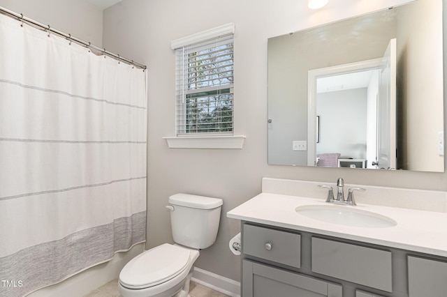 full bath with toilet, vanity, and baseboards