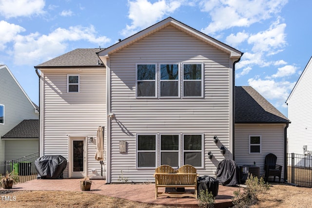 rear view of property featuring a patio area, a shingled roof, fence, and central AC unit