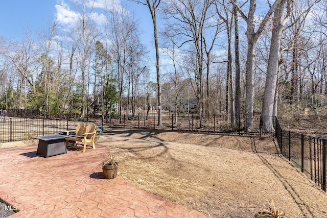 view of yard featuring a fire pit, a patio area, and fence