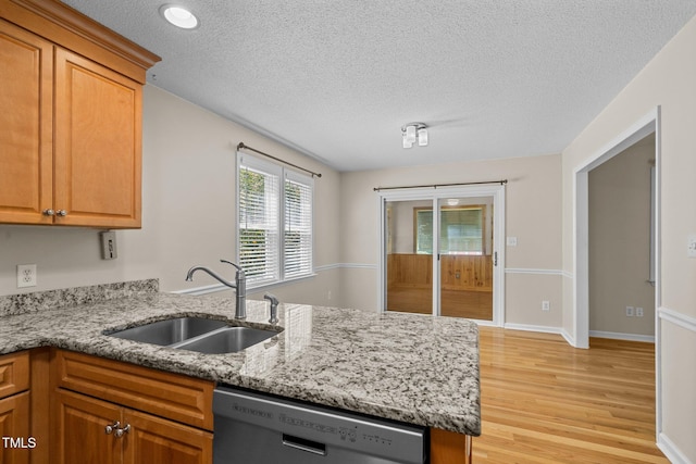 276 Sagamore Dr, Louisburg, NC 27549 - kitchen with light stone counters, stainless steel dishwasher, a textured ceiling, light wood-style floors, and a sink