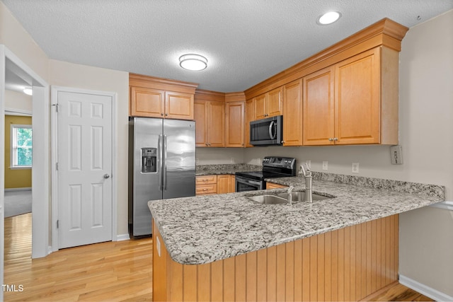 276 Sagamore Dr, Louisburg, NC 27549 - kitchen featuring a peninsula, light stone countertops, appliances with stainless steel finishes, and a sink