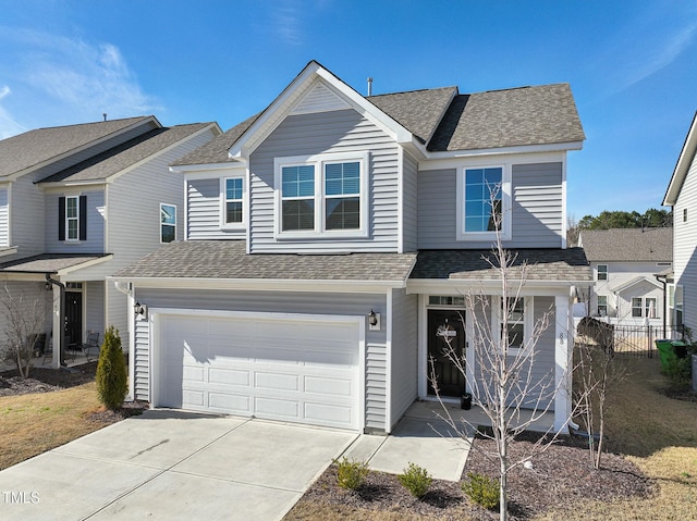 traditional-style house featuring driveway, a shingled roof, and an attached garage