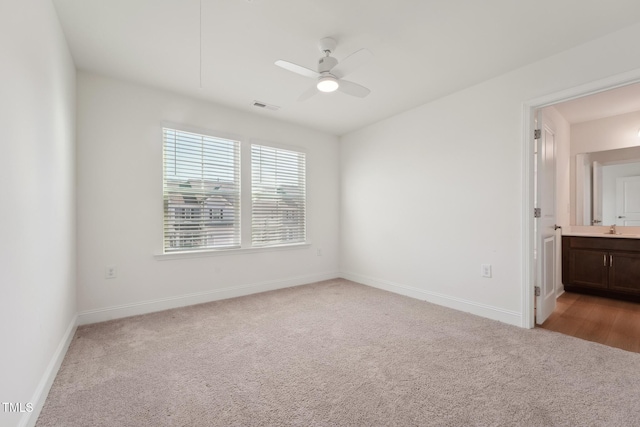 unfurnished room with light carpet, visible vents, and baseboards