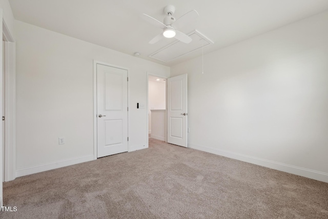 unfurnished bedroom featuring carpet floors, attic access, and baseboards