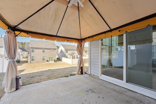 view of patio featuring a gazebo, fence, and a residential view