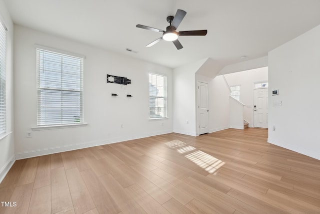 interior space featuring ceiling fan, light wood finished floors, visible vents, and baseboards