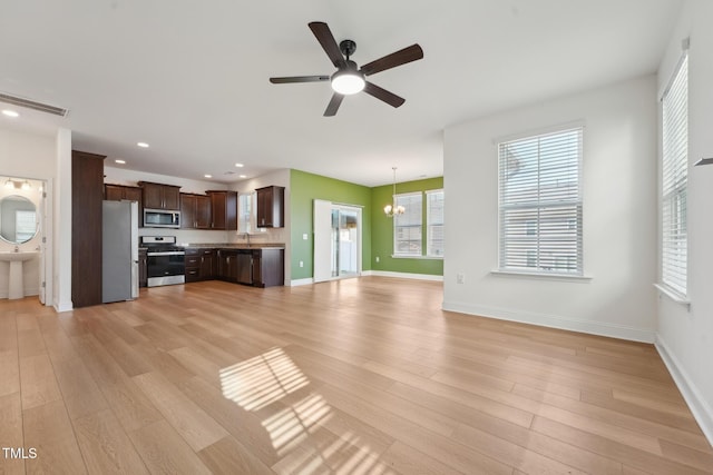 unfurnished living room featuring light wood-type flooring, baseboards, and recessed lighting