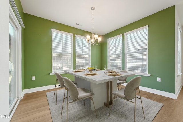 dining area featuring light wood-style floors, visible vents, and plenty of natural light