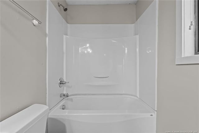 bathroom featuring washtub / shower combination and toilet