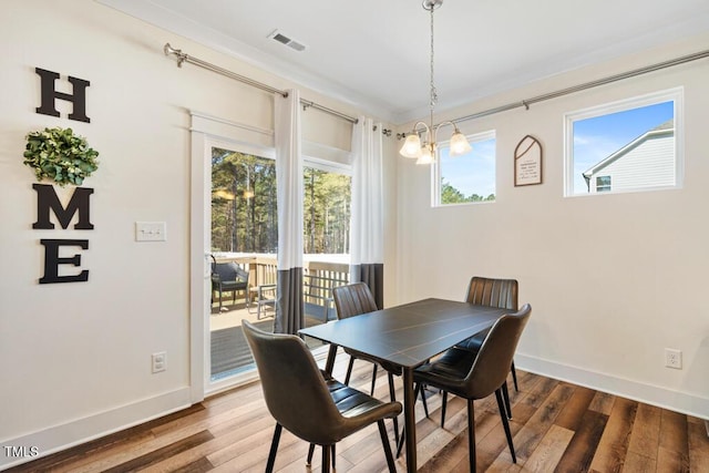 220 Green Haven Blvd, Youngsville, NC 27596 - dining space featuring baseboards, visible vents, wood finished floors, and an inviting chandelier