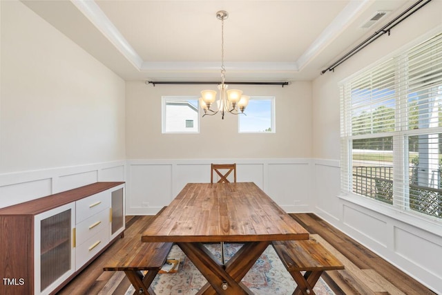 220 Green Haven Blvd, Youngsville, NC 27596 - dining space with a tray ceiling, wood finished floors, a decorative wall, and a notable chandelier