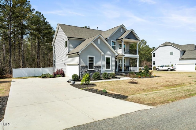 220 Green Haven Blvd, Youngsville, NC 27596 - view of front facade featuring driveway, covered porch, stone siding, fence, and a garage