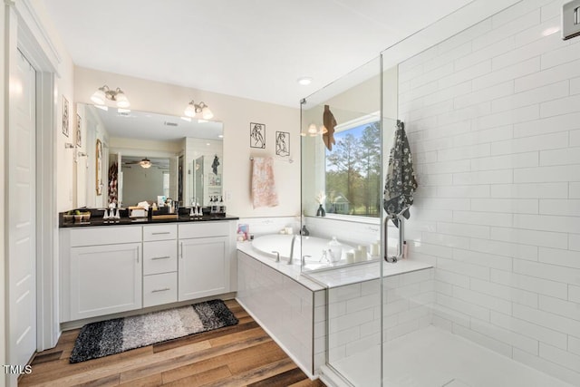 220 Green Haven Blvd, Youngsville, NC 27596 - bathroom with ceiling fan, wood finished floors, vanity, a stall shower, and a garden tub
