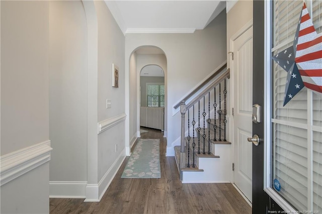 foyer entrance with crown molding and dark wood-type flooring