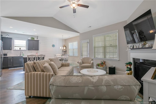 living room with lofted ceiling, sink, ceiling fan with notable chandelier, and dark hardwood / wood-style floors