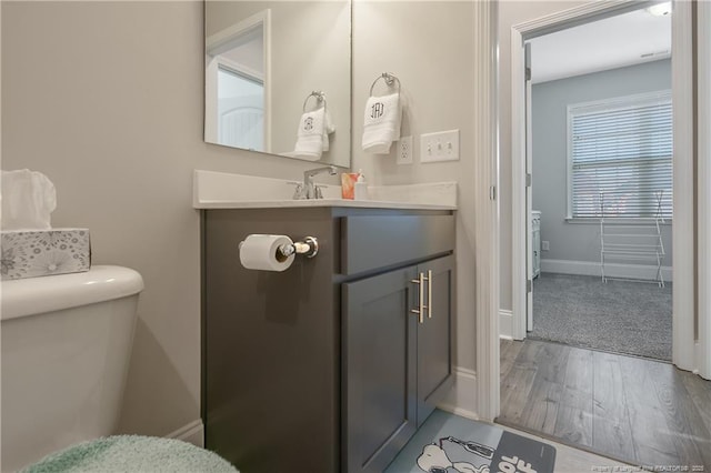 bathroom featuring hardwood / wood-style flooring, vanity, and toilet