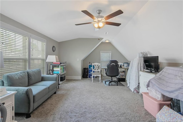 carpeted home office featuring lofted ceiling and ceiling fan