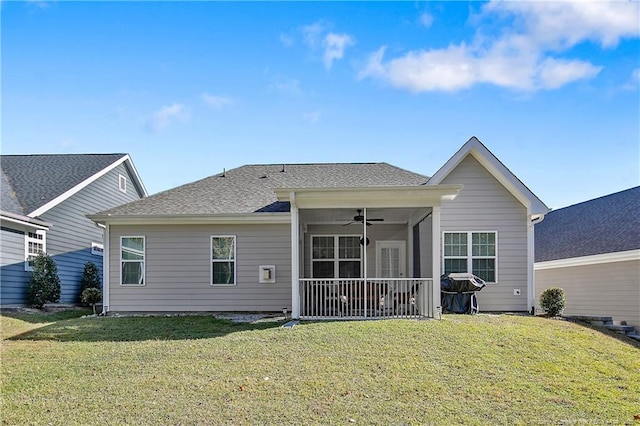 rear view of property featuring a sunroom, ceiling fan, and a lawn