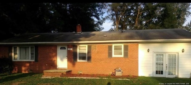 single story home featuring french doors and a front lawn