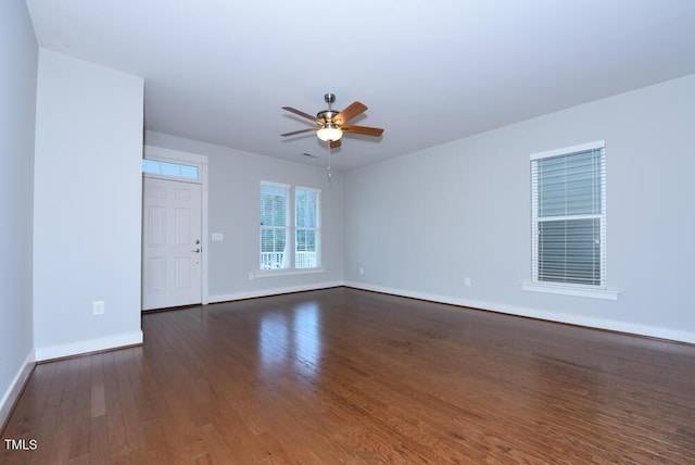 empty room featuring ceiling fan, wood finished floors, and baseboards