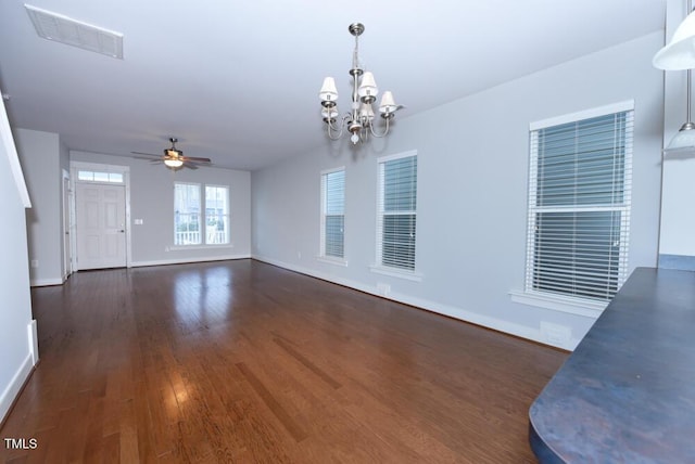 unfurnished living room featuring dark wood-style floors, visible vents, baseboards, and ceiling fan with notable chandelier