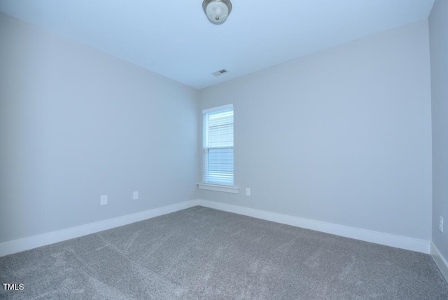 unfurnished room featuring carpet floors, visible vents, and baseboards