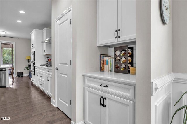 208 Cecelia Ct, Cary, NC 27519 - bar featuring dark wood-type flooring, double oven, recessed lighting, gas stovetop, and under cabinet range hood