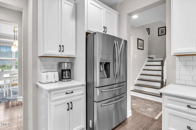 208 Cecelia Ct, Cary, NC 27519 - kitchen featuring stainless steel fridge with ice dispenser, wood finished floors, white cabinetry, tasteful backsplash, and light countertops