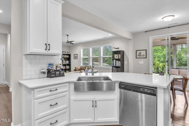 208 Cecelia Ct, Cary, NC 27519 - kitchen featuring stainless steel dishwasher, a sink, light countertops, a peninsula, and wood finished floors