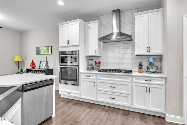 208 Cecelia Ct, Cary, NC 27519 - kitchen featuring stainless steel appliances, wall chimney exhaust hood, light countertops, and recessed lighting