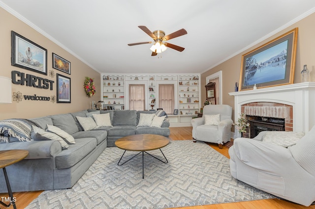 living room with crown molding, wood-type flooring, and a brick fireplace