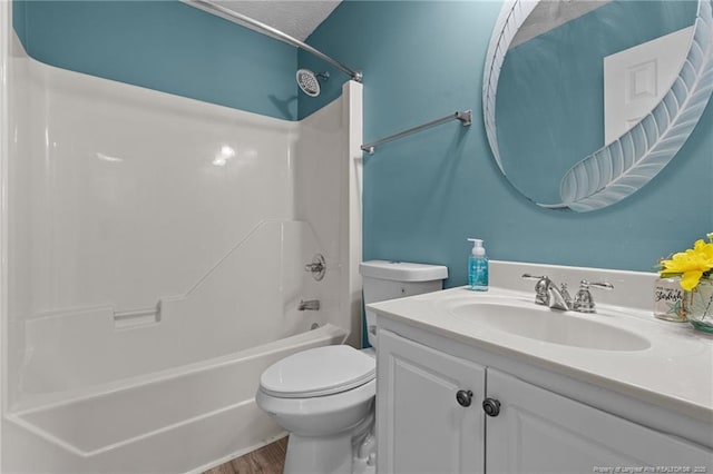 full bathroom with hardwood / wood-style floors, vanity, toilet, and  shower combination