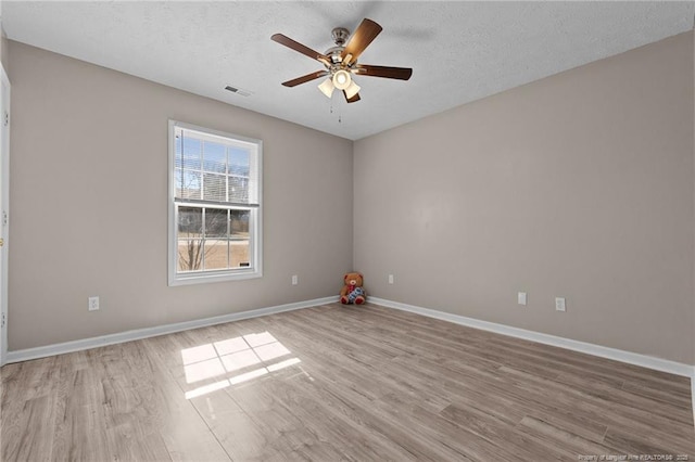 unfurnished room featuring ceiling fan, light hardwood / wood-style floors, and a textured ceiling