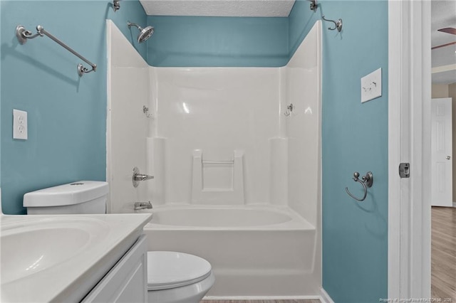 full bathroom with washtub / shower combination, hardwood / wood-style floors, vanity, a textured ceiling, and toilet