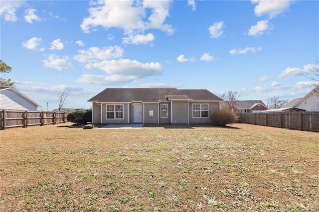 back of property with a lawn and a patio area